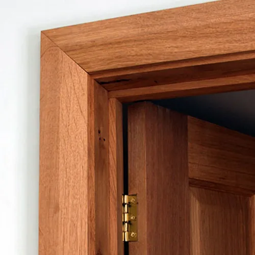 Close-up of a Dormak wooden door frame with a brass hinge